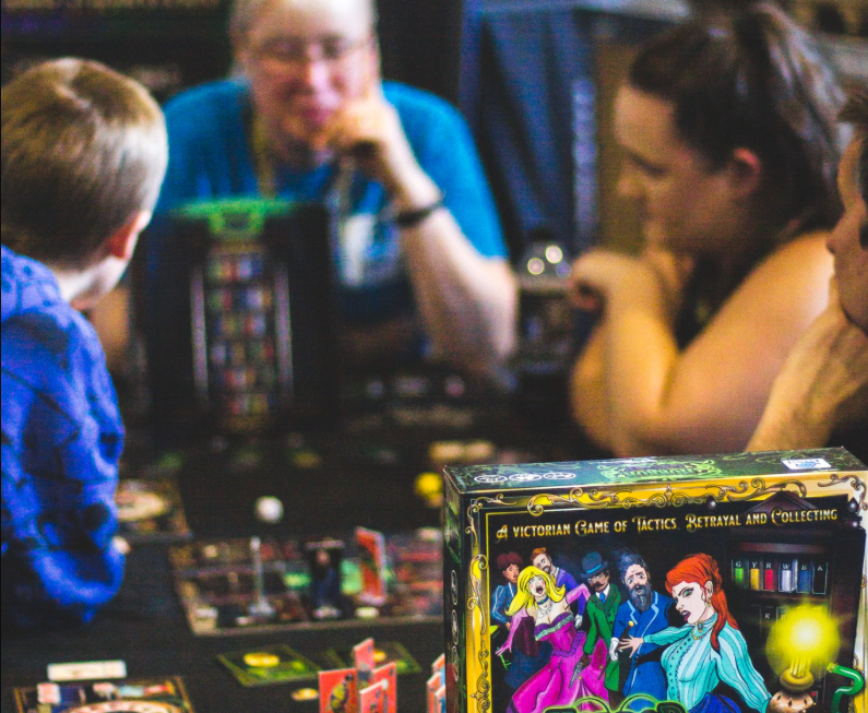 Players learning Horror in the Library at a public event, cropped to show a welcoming beginner-friendly table scene