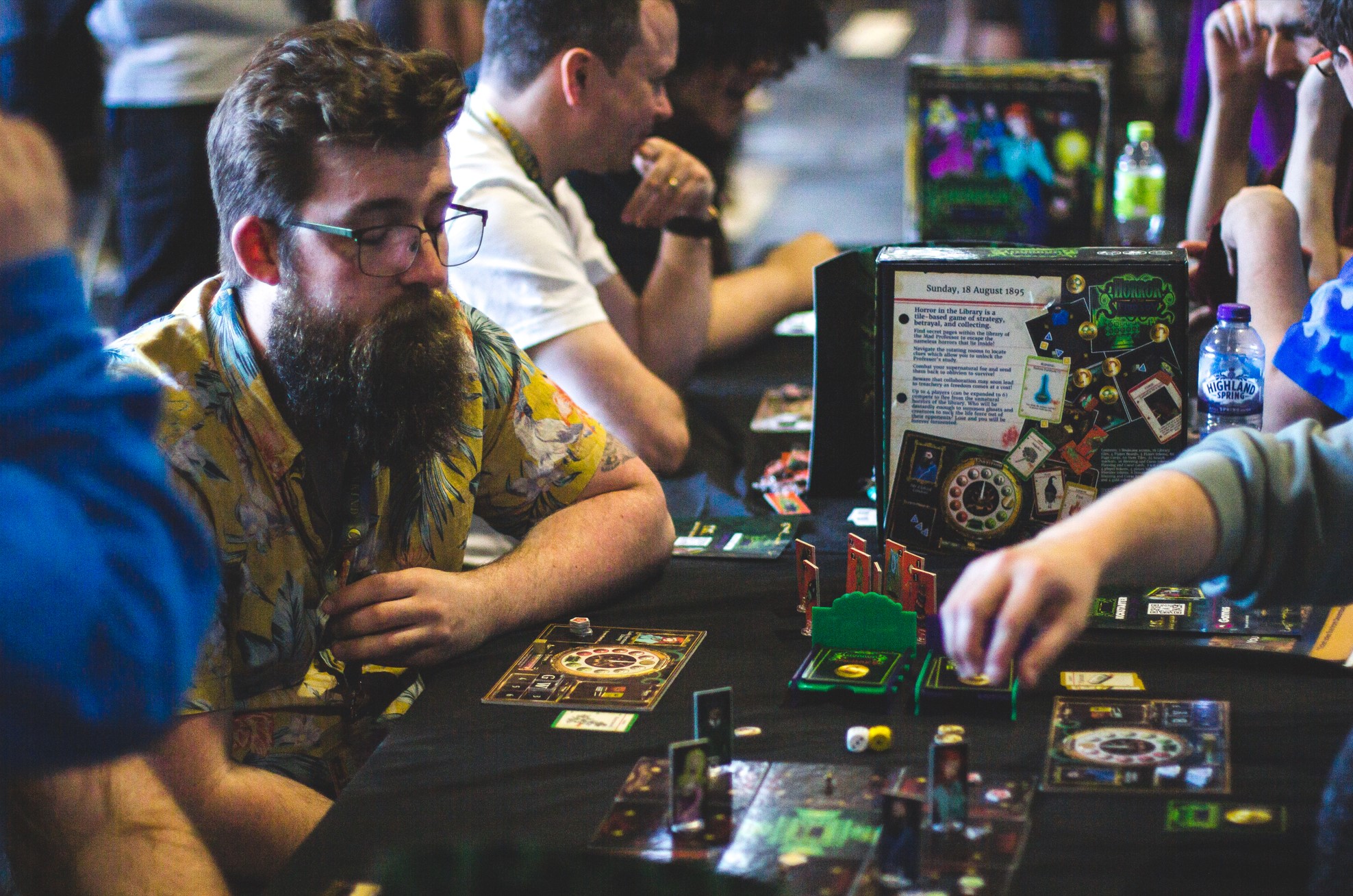 Horror in the Library demo table with the game box and live players at an event